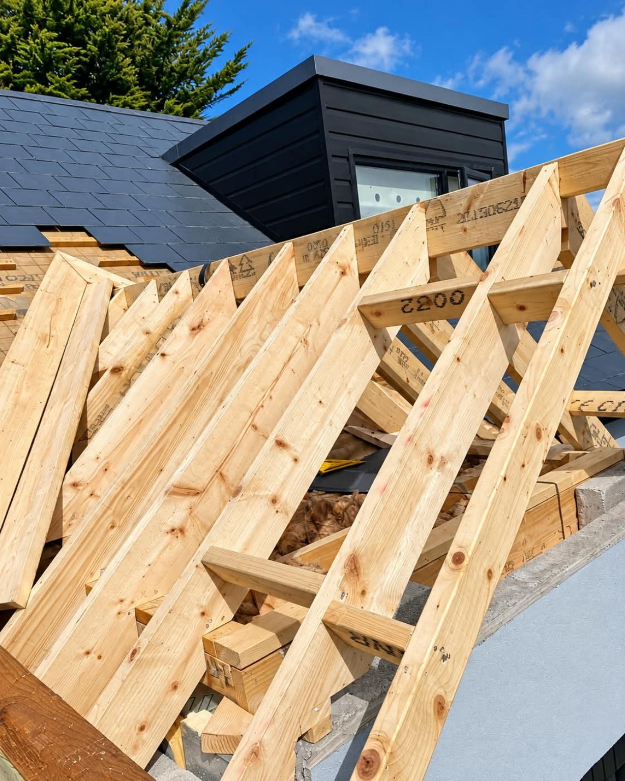 New timber roof rafters being fitted by A&C alongside a slated roof and dormer